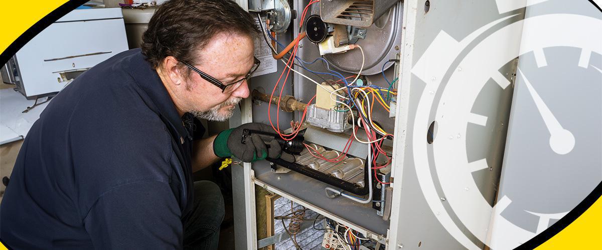 HVAC tech inspecting furnace