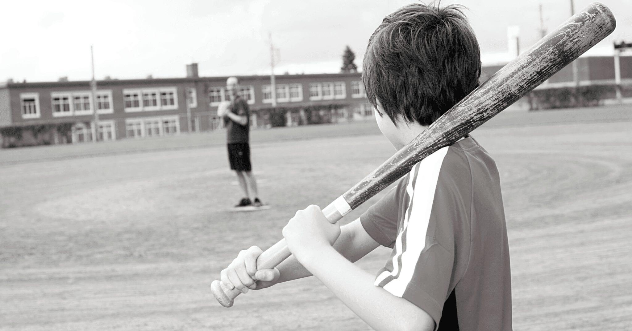 black and white image of child with baseball bat