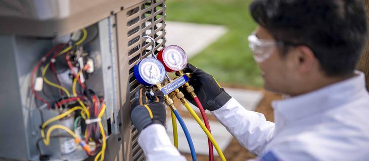 Technician checking air conditioning unit gauges