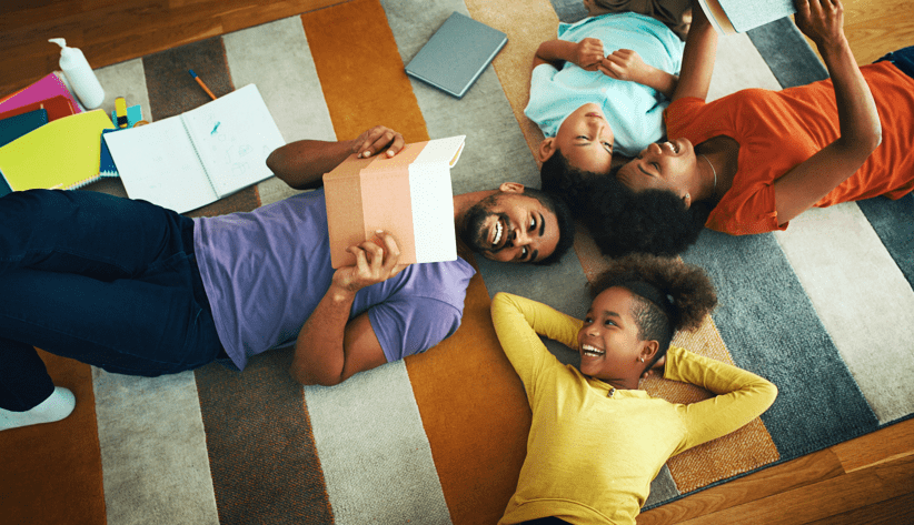 Black Family Laying On Ground In Home