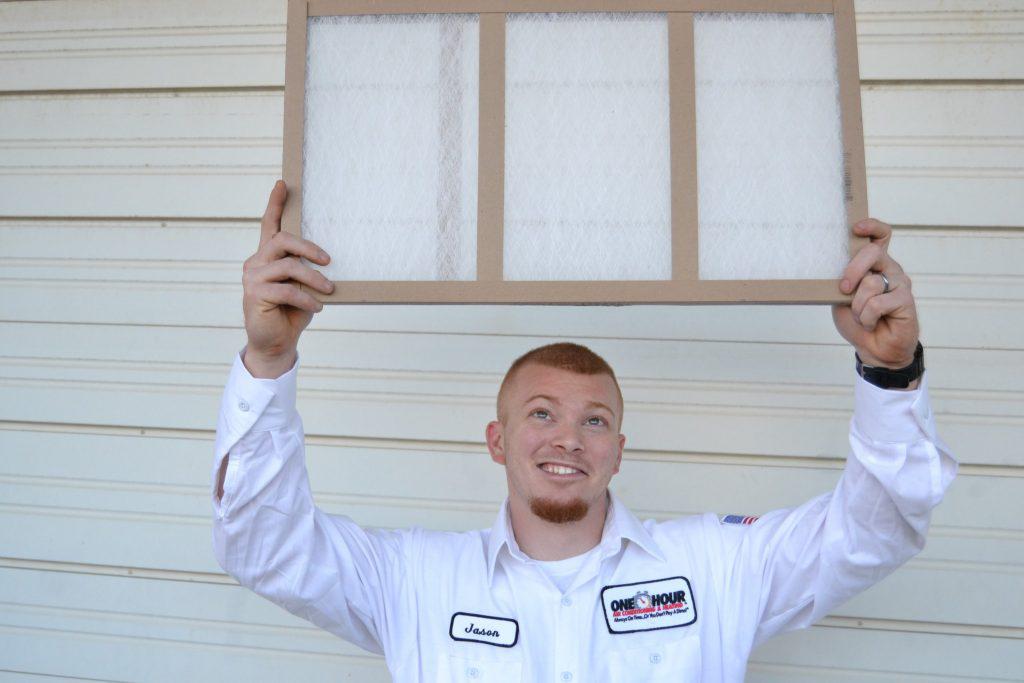 One Hour Technician Looking at an Air Conditioning Filter 