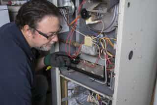 HVAC Technician Performing Maintenance on a HVAC Unit