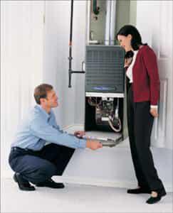 HVAC technician showing homeowner a furnace