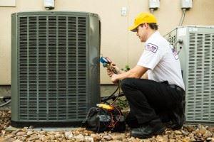 Technician installing a heat pump by a home