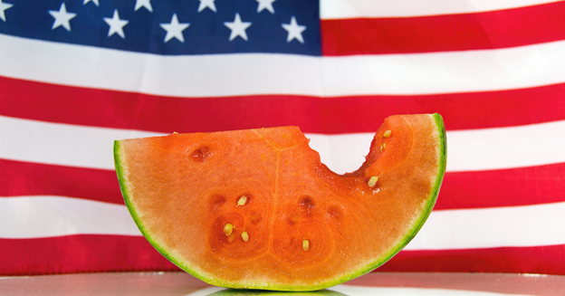 A watermelon infront of a 4th of July flag