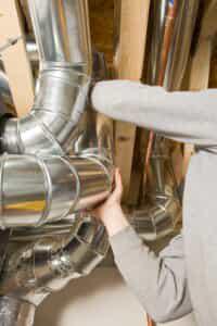 Repair person inspecting ductwork