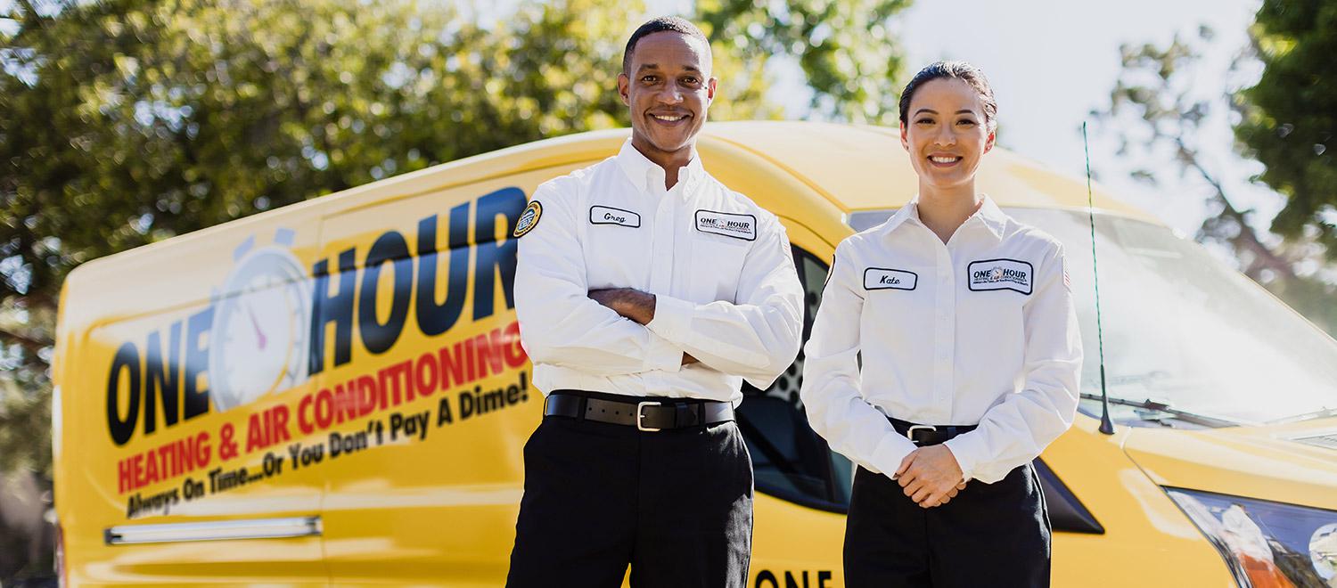Two technicians posing in front of van