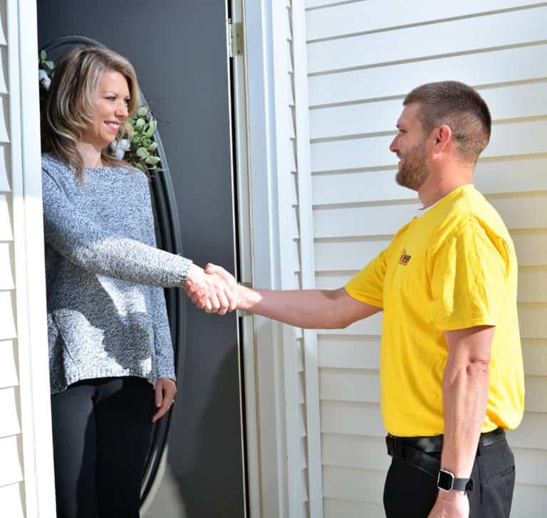 Pass One Hour technician shaking hands with a customer at her door