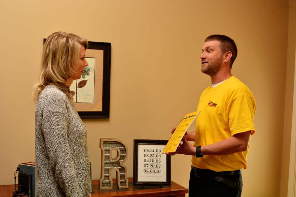 Pass One Hour technician speaking with a customer in her home