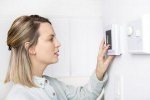 Woman adjusting thermostat