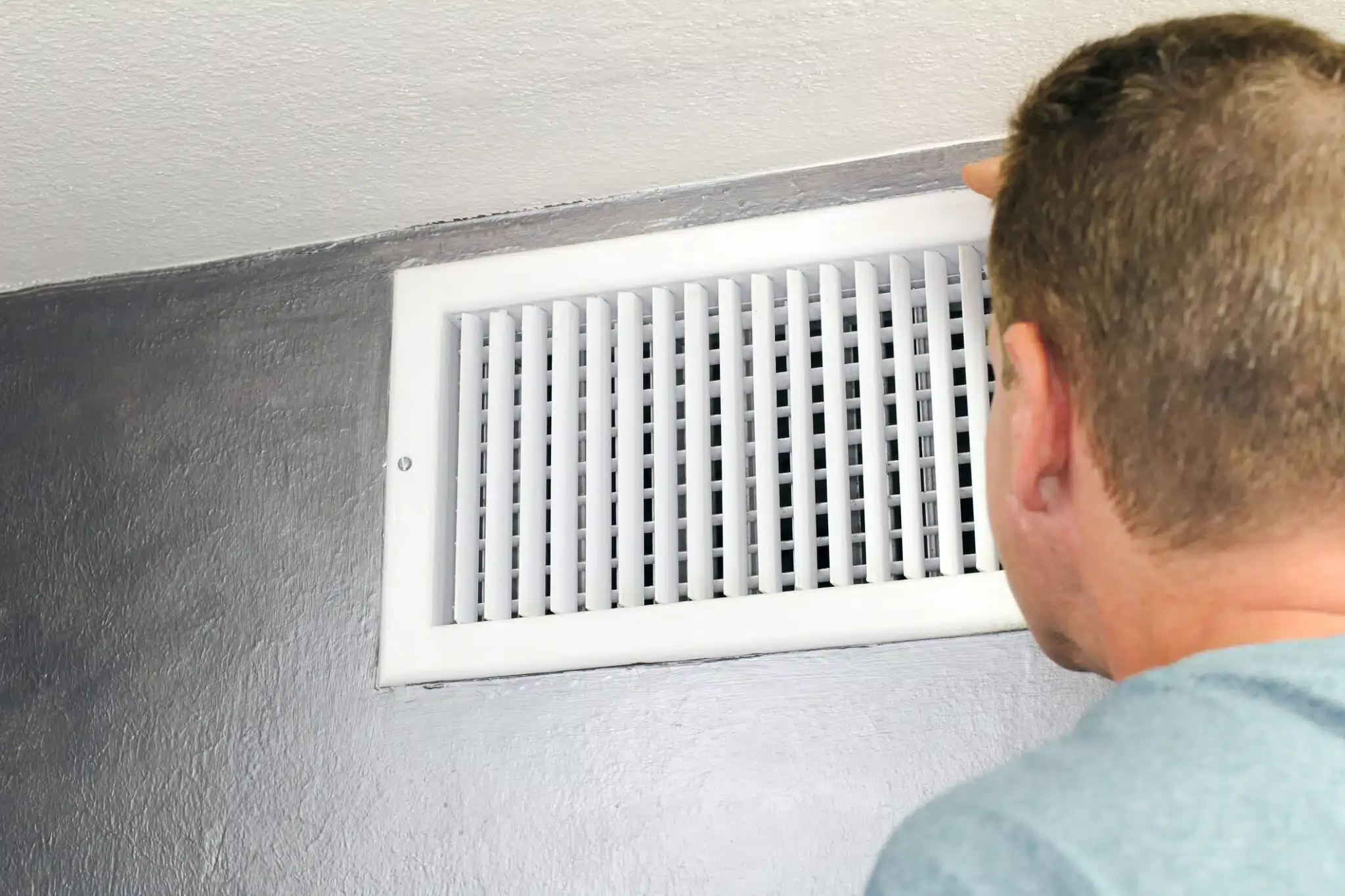 man looking at air vent