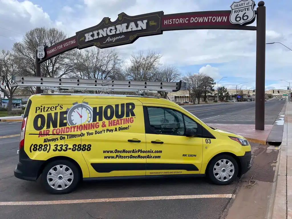 One Hour Air Conditioning and Heating truck in front of Kingman, AZ sign