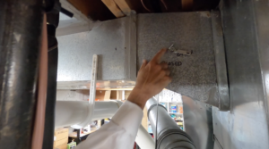 fingr pointing to writing on HVAC system