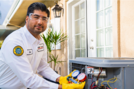 HVAC tech looking at camera holding tool to inspect unit