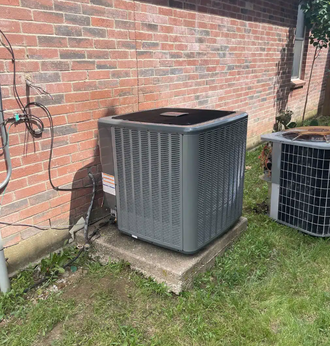 AC unit on cement slab next to brick house