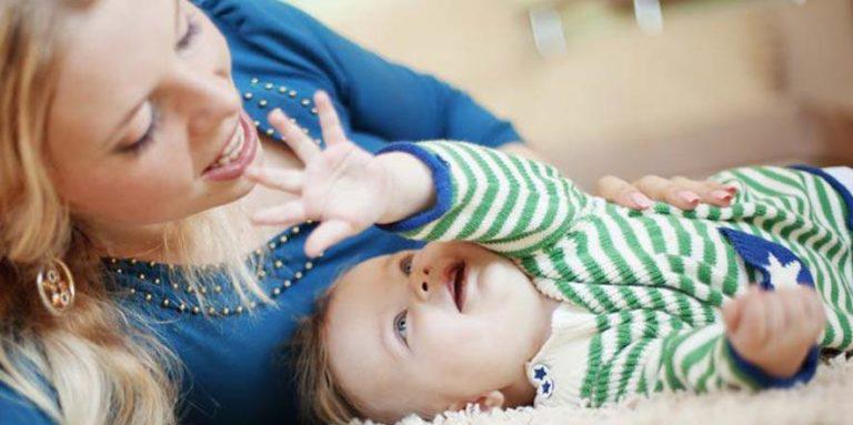 A mother and baby boy playing with each other 