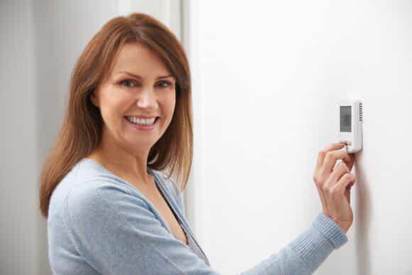 Woman Using a Thermostat